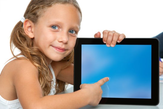 Young girl holding a tablet and pointing at the screen