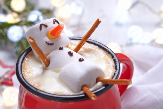 Red mug with hot chocolate and snowman made of marshmallows
