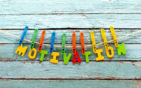 Letters hanging from a rope spelling out the word “Motivation”