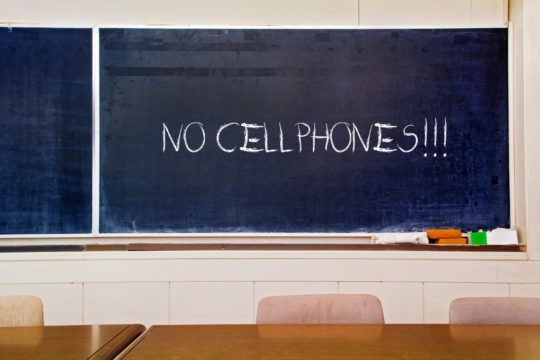‘NO CELLPHONES!’ written on a classroom chalkboard.