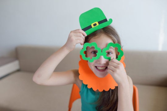 Young girl dressed up as a leprechaun and smiling.