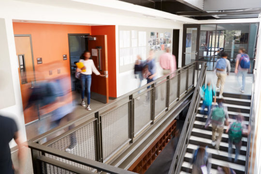 Busy school hallways as students walk between classes.