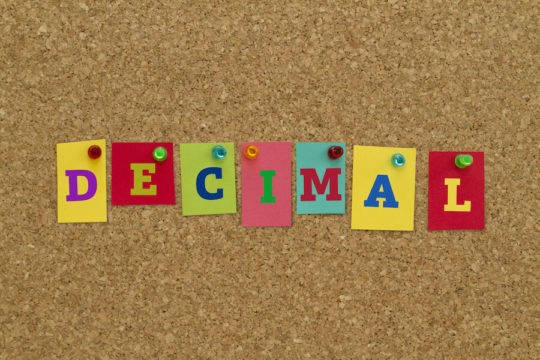 The word ‘Decimal’ written on sticky notes pinned to a corkboard