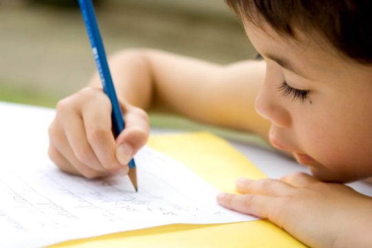 Young boy does writing as part of his homework.