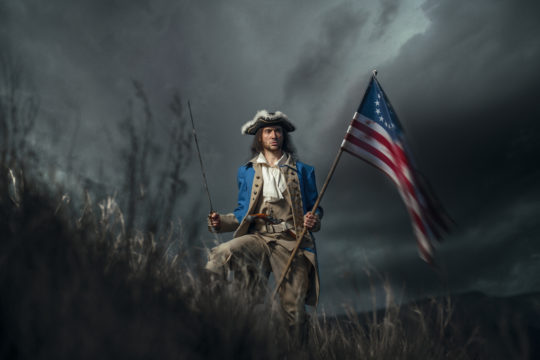 American Revolution war soldier holding American flag