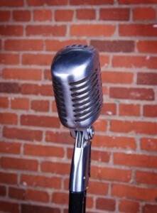 Microphone on a stand in front of a brick wall